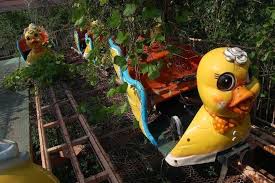 Abandoned duck themed roller coasters with plants and weeds growing out of them
